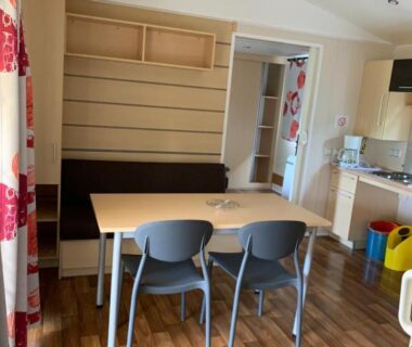 Intérieur coin repas et kitchenette dans le mobil-home PMR