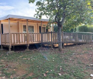Terrasse et rampe d'accès dans un espace herbeux du mobil-home PMR