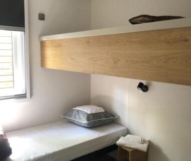 Chambre avec lits superposés et fenêtre dans le mobil home PREMIUM 35m2 3 chambres 6 personnes