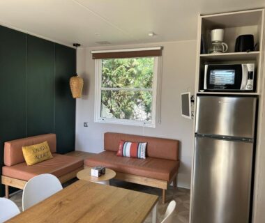 Séjour avec kitchenette canapé et table dans le Mobil home PREMIUM 35m2 3 chambres 6 personnes