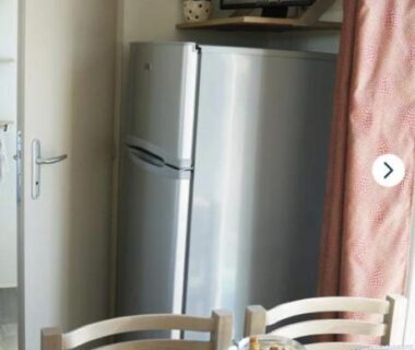 Cuisine ouverte avec table et réfrigérateur du Mobil-home Paradis Bleu