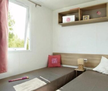 Chambre intérieure avec lits jumeaux et fenêtre dans le Mobil-home Paradis Bleu