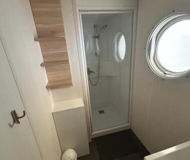 Salle de bains avec cabine de douche et hublot du Mobil home Parc des 7 Fonts Les Cigales 4 pers