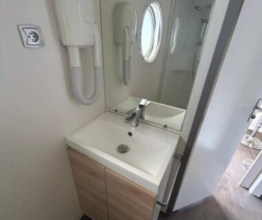 Salle de bain avec lavabo et sèche-cheveux dans le Mobil home Parc des 7 Fonts Les Cigales 4 pers