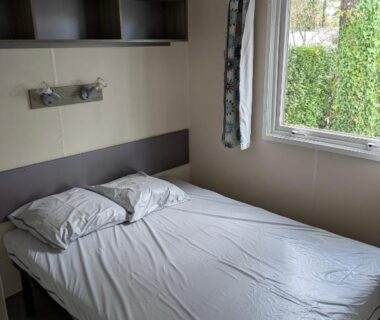 Chambre avec lit double et fenêtre dans le mobil home Phoenix 6 places