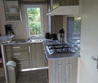 Intérieur cuisine avec évier plaques et rangements dans le mobil home Phoenix 6 places