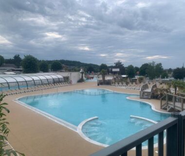 Piscine extérieure avec bassin partiellement couvert et passerelle au Mobil home Premium