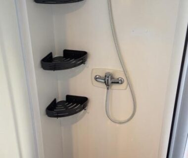 Cabine de douche avec pommeau et étagères dans le mobil-home Premium 3ch au Camping les Dunes à Torreilles