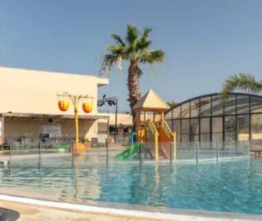 Piscine extérieure avec toboggan et transats au Mobil-home Premium 3ch 6 pers du Camping les Dunes à Torreilles