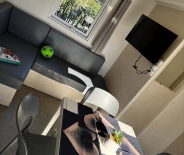 Intérieur avec banquette table et télévision dans le Mobil-home Premium 3ch 6 pers Camping les Dunes à Torreilles