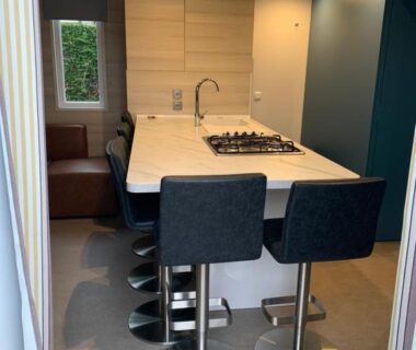 Cuisine intérieure avec comptoir évier et tabourets dans le Mobil home Premium