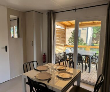 Terrasse couverte avec table et chaises visible depuis le séjour du Mobil home Premium 6p