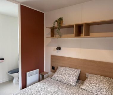 Chambre avec lit double et WC visibles dans le Mobil home Premium 6p Camping 4 étoiles Face à la mer