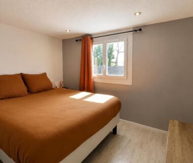 Chambre avec lit double et télévision dans le Mobil-home Premium Piscine BBQ et Home Cinéma