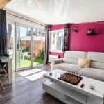 Salon lumineux avec baie vitrée et canapé dans le Mobil-home Premium Piscine BBQ & Home Cinéma