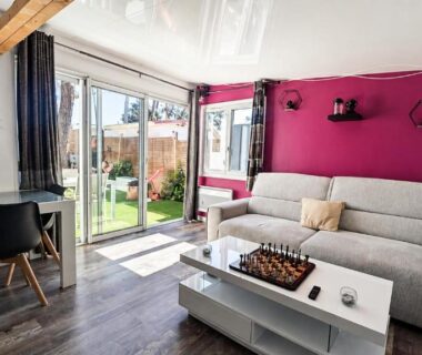 Salon lumineux avec baie vitrée et canapé dans le Mobil-home Premium Piscine BBQ & Home Cinéma