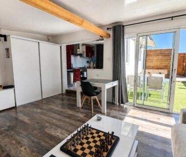 Séjour avec baie vitrée et coin salon dans le Mobil-home Premium Piscine BBQ et Home Cinéma