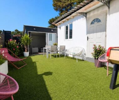 Terrasse extérieure avec chaises, table et baby-foot du Mobil-home Premium Piscine BBQ et Home Cinéma