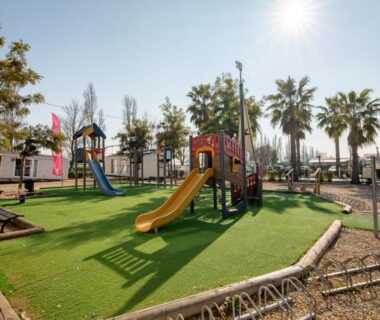 Aire de jeux avec toboggan et pelouse au camping Mobil home Queen Margaret