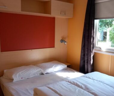 Chambre double avec deux lits et fenêtre dans le Mobil-home Riviera