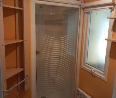 Salle de bain avec cabine de douche et vasque du Mobil-home Riviera