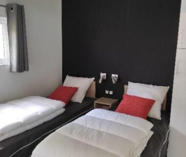 Chambre avec deux lits simples et table de chevet dans le mobil home TAOS Luxe H20 du Camping de Lanniron