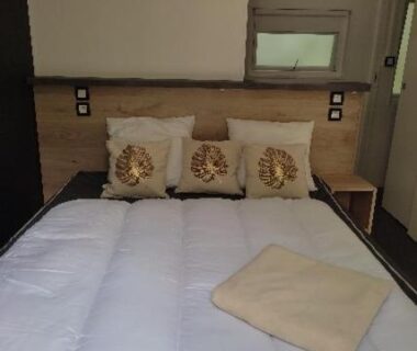 Chambre avec lit double et coussins dans le mobil home TAOS Luxe H20