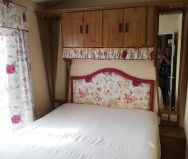 Intérieur chambre avec lit double et placards en bois du Mobil home Vergnelibert