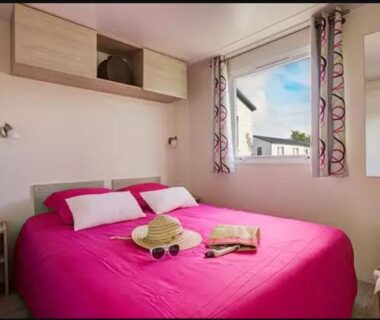 Chambre double avec lit et fenêtre dans le mobil home XL 6 personnes du Camping La Pommeraie de l'Océan