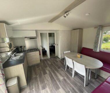 Intérieur avec kitchenette et coin repas dans le Mobil home XL 6 personnes du Camping La Pommeraie de l'Océan