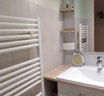 Salle de bains avec lavabo et sèche-serviettes dans le Mobil-home à Hourtin terrasse piscine proche lac et océan