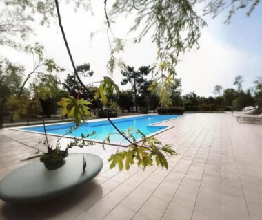 Terrasse carrelée avec piscine et chaises longues du Mobil-home à Hourtin