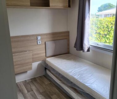 Chambre avec lit simple et rangements dans le mobil-home à Lattes