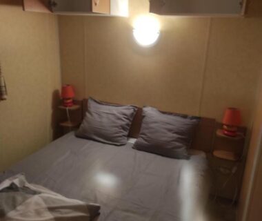 Chambre avec lit double et lampes dans le Mobil home agreable et fonctionnel
