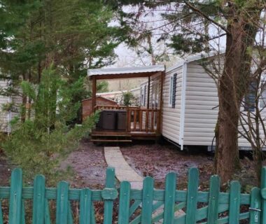 Terrasse en bois et chemin bordé d'arbres du Mobil-home alex