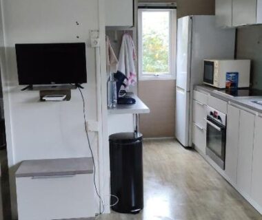 Intérieur avec kitchenette télévision et porte-fenêtre du Mobil-home alex