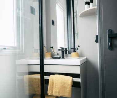 Salle de bains avec lavabo miroir paroi de douche et serviette jaune du Mobil home animaux admis 7 pers API-1-52-2257