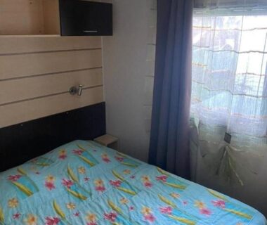 Chambre avec lit double fenêtre et télévision dans le Mobil-home au Camping familial 4 étoiles Les Sables d'Or