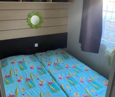 Chambre avec deux lits et fenêtre dans le mobil-home au Camping familial 4 étoiles Les Sables d'Or