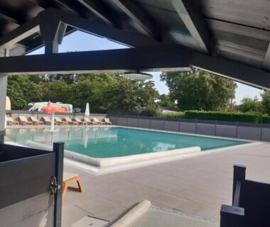 Terrasse couverte avec piscine et transats du Mobil home au bord du lac de Foix