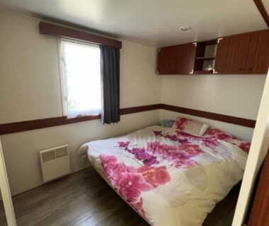 Chambre avec lit double et rangement dans le mobil-home n°507 au camping La Lande
