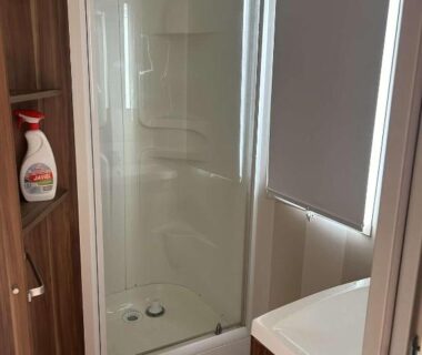 Salle de bain avec cabine de douche et lavabo dans le Mobil home au castellas marseillan