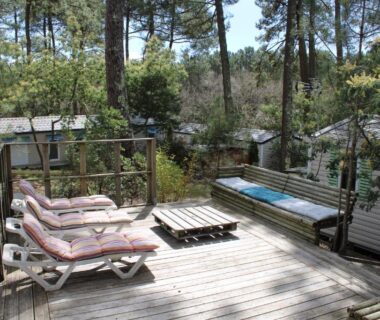 Terrasse en bois avec transats et banc au mobil-home au cœur des pins by Siblu Les Embruns Lège Cap Ferret