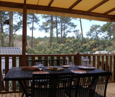 Terrasse couverte avec table et chaises dans le Mobil-home au cœur des pins by Siblu Les Embruns Lège Cap Ferret