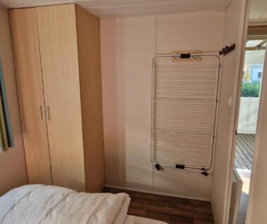 Chambre intérieure avec lit placard et radiateur dans le Mobil-home avec grande terrasse