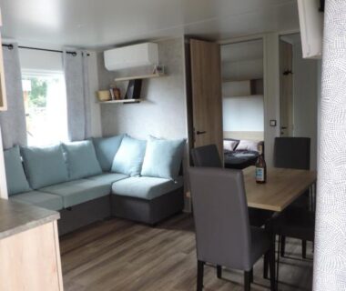 Intérieur coin salon avec canapé et table à manger du mobil home proche plages Cap-Ferret Camping Les Viviers