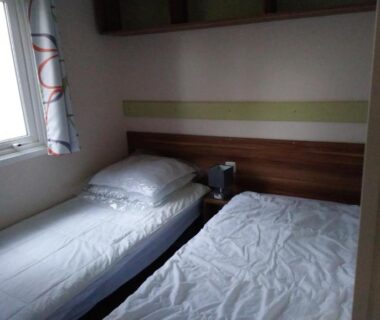 Intérieur chambre avec deux lits dans le mobil home camping 4 étoile