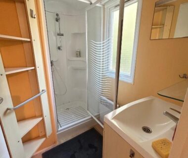 Salle de bain avec cabine de douche et lavabo dans le Mobil home camping Lalande Mimizan