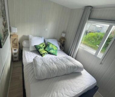 Chambre avec lit double et gigogne près de la fenêtre dans le mobil home Paradis du Quinquis