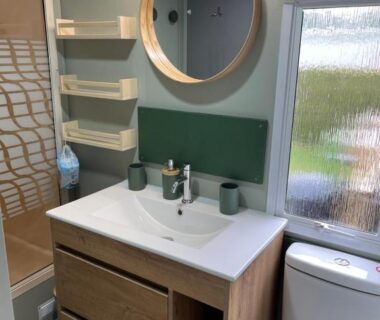 Salle de bain avec lavabo miroir et cabine de douche du mobil home camping Paradis du Quinquis